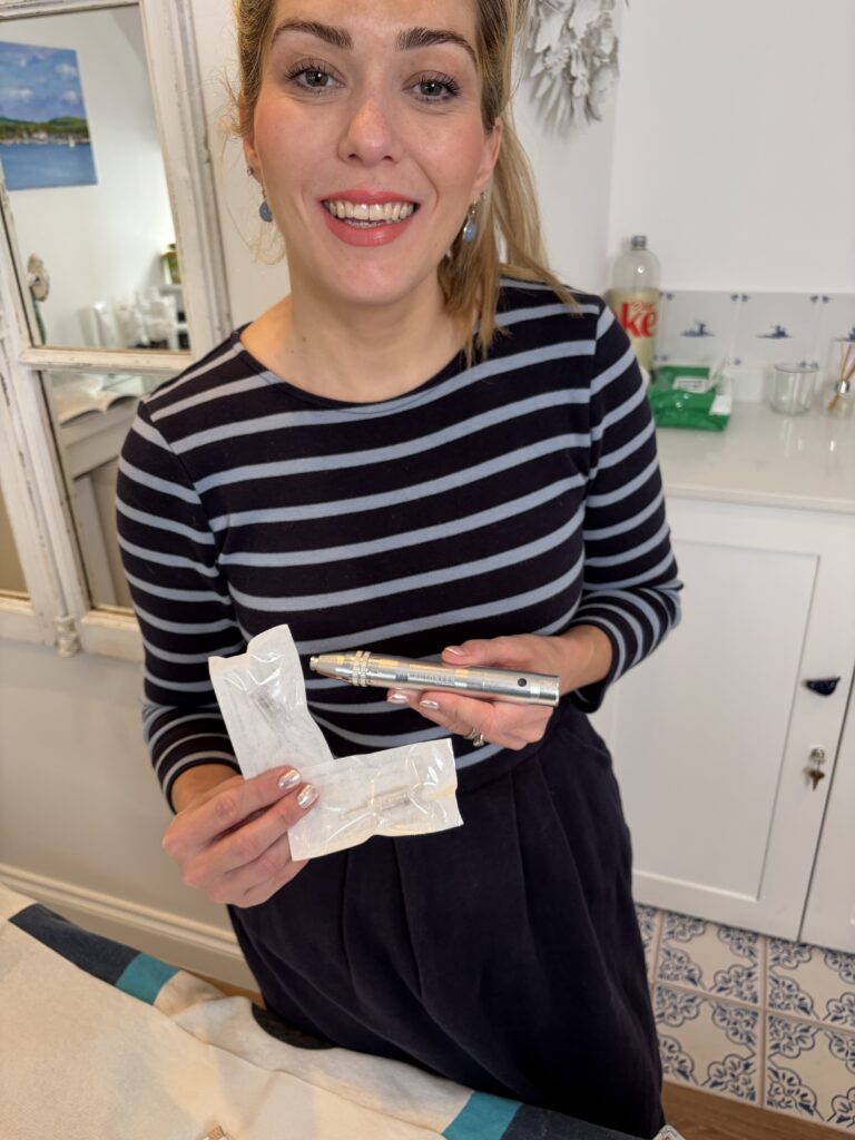 Dr Amber Halliday holding a sterile microneedling cartridge and device in the clinic treatment room.