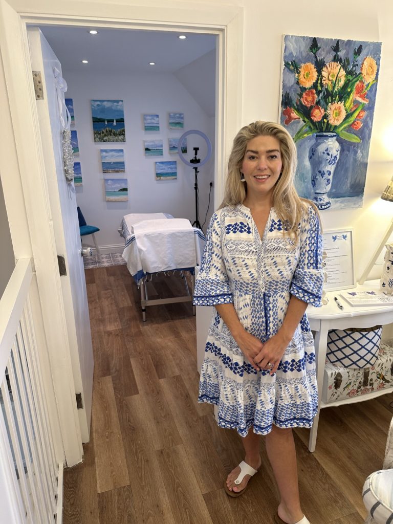 Dr Halliday standing outside the clinic room at Blue Bird Aesthetics