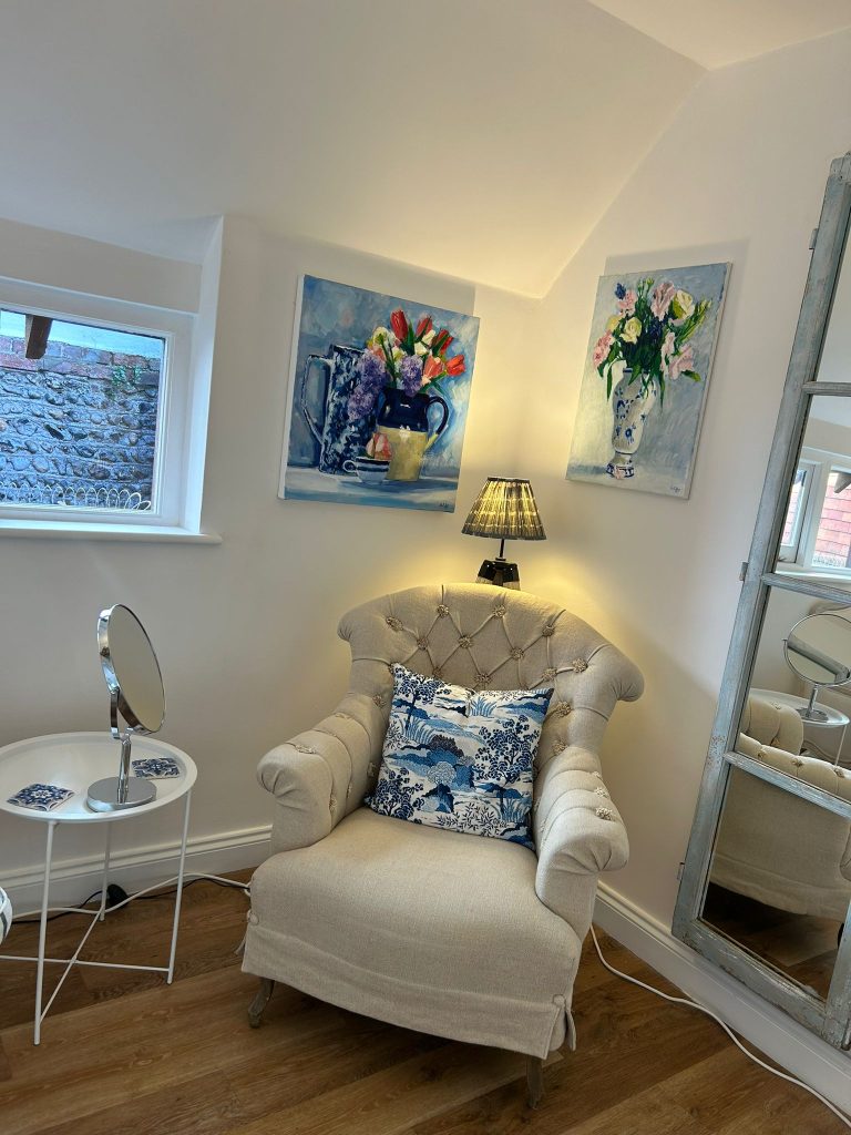 Comfortable consultation area at Blue Bird Aesthetics with armchair and decorative artwork.