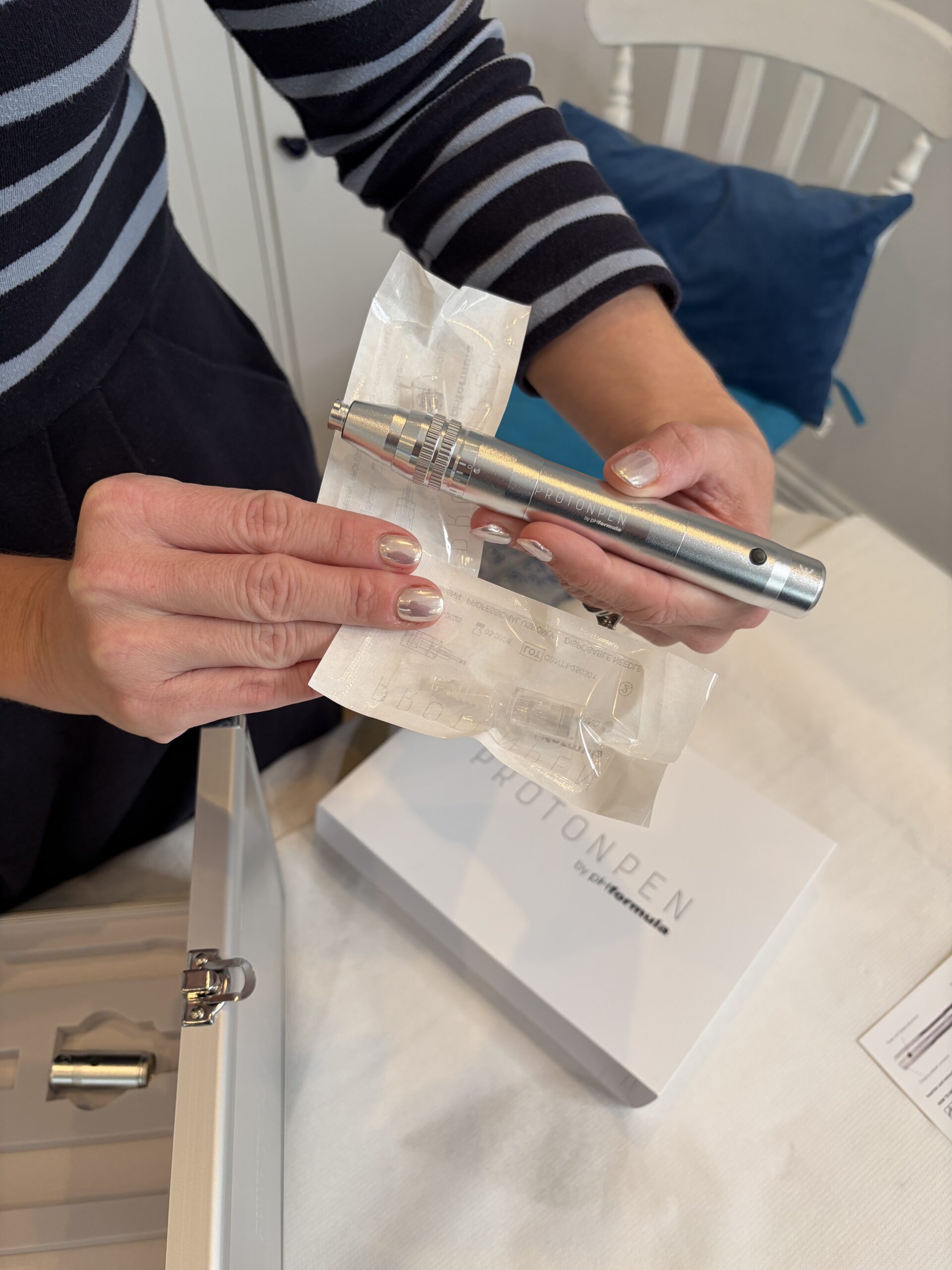 Close‑up of Dr Halliday holding the the Proton Pen, showing only her hands and the Microndeeling device.