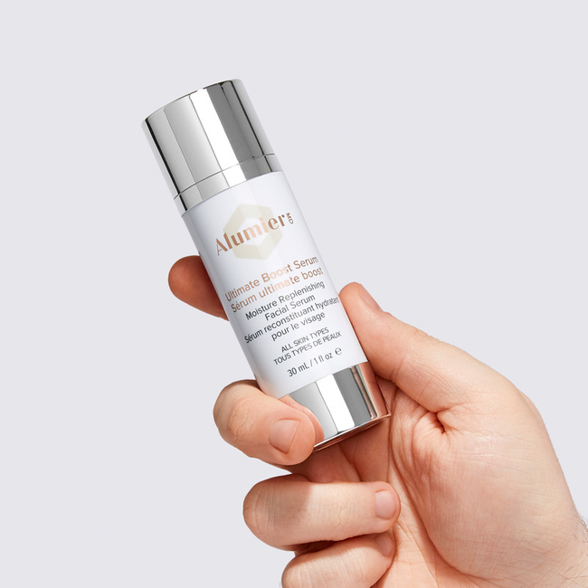 Hand holding AlumierMD Ultimate Boost Serum, a hydrating medical‑grade facial serum recommended by Dr Amber Halliday.