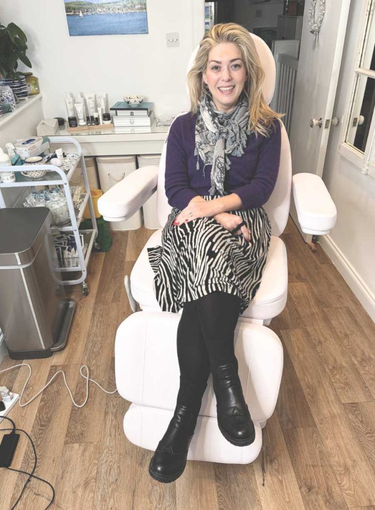 Dr Amber Halliday seated comfortably in the Blue Bird Aesthetics treatment room, showing the calm, professional environment where doctor‑led aesthetic treatments take place