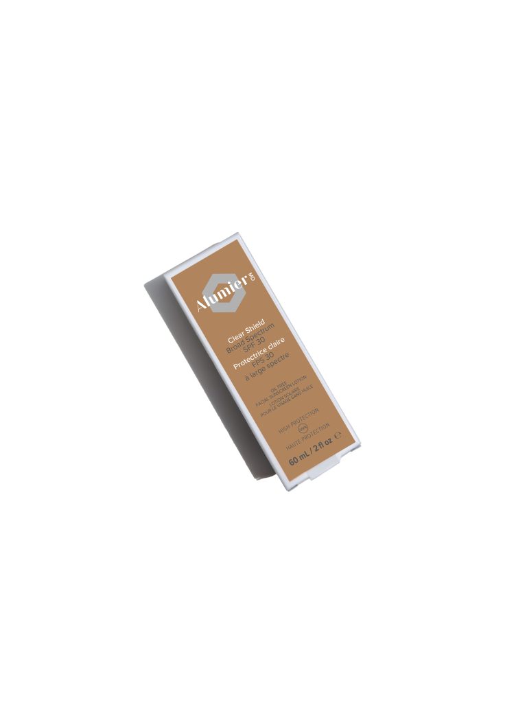 Bottle of Alumier Clear Shield Broad Spectrum SPF 42 facial sunscreen standing upright with tan and white packaging.